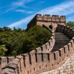 Legacy 6 The Great Wall of China surrounded by lush greenery under a clear blue sky.